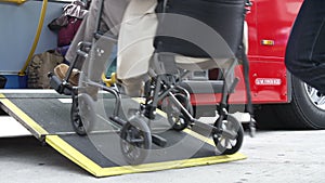 Close Up Of Disabled Person In Wheelchair Boarding Bus