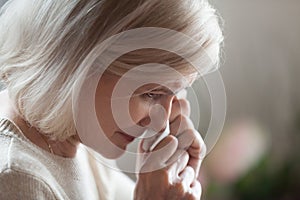 Close up of disappointed aged woman wiping tears crying