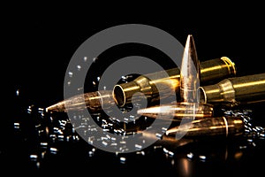 Close-up of disassembled rifle cartridges. Bullet isolated on black background with reflexion. Granulated gunpowder