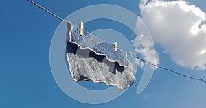 Close up on a dish washing cloth hanging from a metal wash line