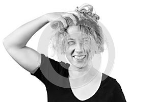 Close-up of a disheveled girl laughing holding her head and ruining her hair. B W toning. The concept of emotions of joy