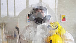 Close up disinfector in overalls processes a surface by means of a spray slow mo