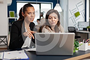 Close up of diverse businesswomen checking graphs from laptop