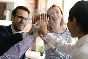 Close up diverse employees team giving high five, celebrating success