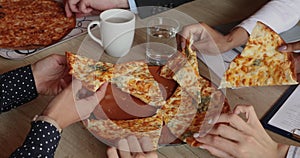 Close up diverse human hands taking pizza.