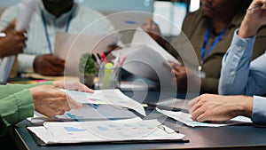 Close up of diverse specialists evaluating data numbers on archived files
