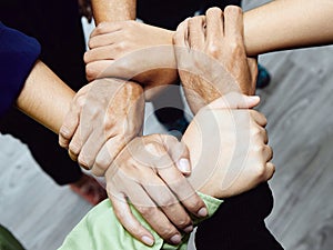 A close-up of a diverse team's hands interlocked, symbolizing unity, teamwork, and partnership