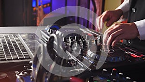 Close up of DJ hands playing music, mixing. Dj Mixer Controller Desk in Night Club Disco Party. DJ Hands touching