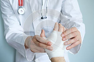 Close up of doctor bandaging one hand