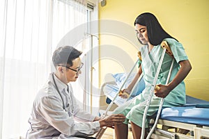 Close-up of Doctor examining female patient with injured leg or knee in clinic, Sport exercise injuries