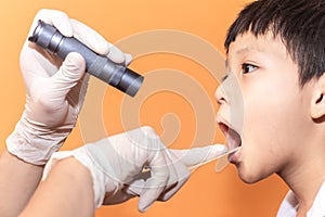 Close up doctor examining throat of patient with tongue depressor