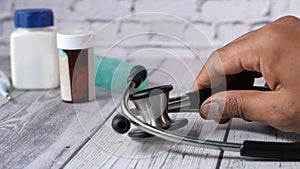 Close up of doctor hand putting stethoscope on table