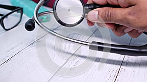 Close up of doctor hand putting stethoscope on table