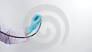 Close up of doctor hand wearing blue latex gloves and holding stethoscop on white background photo