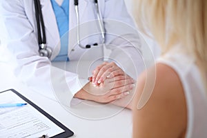 Close up of doctor hands reassuring her female patient