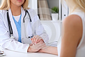 Close up of doctor hands reassuring her female patient