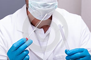 Close-up Of A Doctor Holding DNA Swab Of Saliva