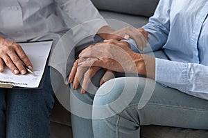 Close up doctor holding older woman patient hand, expressing support