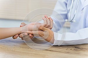 Close up of a doctor holding the patient hands doing basic medical examination and diagnostic