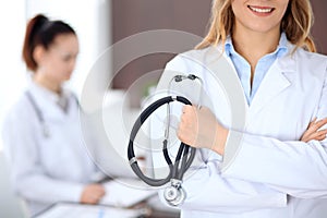 Close up of a doctor holding a stethoscope in his hand while standing in medical office