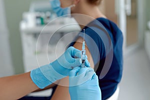 Close up doctor holding syringe  make injection to patient in medical mask.