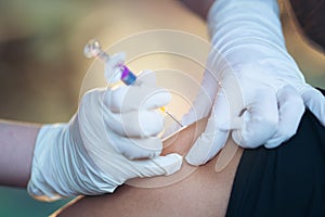 Close up of doctor injecting flu vaccine to patient`s arm in local home