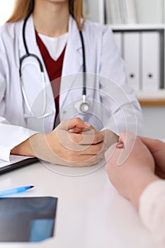 Close up of a doctor and patient hands while discussing medical records after health examination