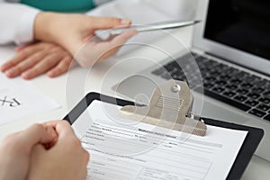 Close-up of a doctor and patient sitting at the desk while physician pointing into laptop computer. Medicine and heal