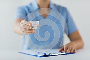 Close up of doctor with pills in medical cup