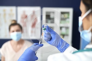 Close up of doctor preparing syringe for patient