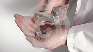 Close-up of a doctor`s hand who is getting of all pills from blister pack and taking them