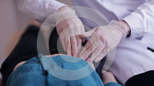 Close-up of doctor`s hands in gloves do palpation patient