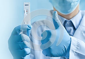 doctor's hands in medical gloves holding negative self testing hepatitis C virus (HCV) test
