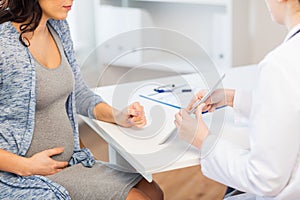 Close up of doctor with tablet and pregnant woman