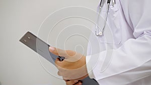 Close-up, doctor taking note of patient`s history on clipboard