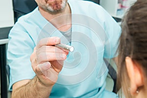 Close up doctor testing reflexes of the eye of young woman using a lamp in medical clinic. Neurological physical examination. Sele photo