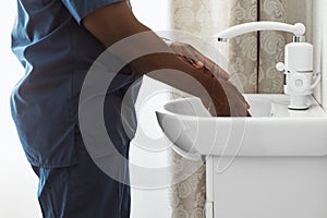 Close-up doctor, therapeutic or medical advisor washing his hands before surgery at medical office, idoors . Concept of