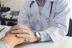 Close up of doctor touching patient hand for encouragement and e