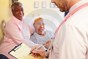 Close Up Of Doctor Updating Patient Notes