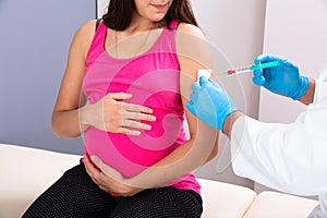 Doctor Vaccinating Young Pregnant Woman