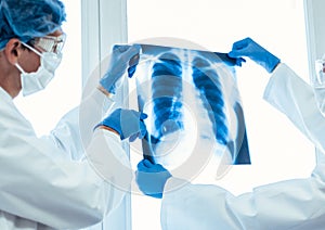 Close up. doctors in protective masks looking at an x-ray of the lungs .