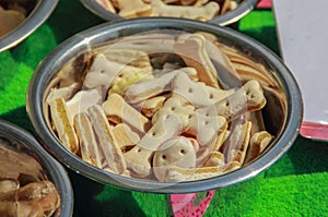 A close up of dog`s bisquits in metal bowl.