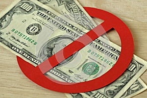 Close-up of dollar bank notes in prohibition sign - No money concept