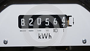 A close-up of a domestic electric meter and measuring dial numbers.
