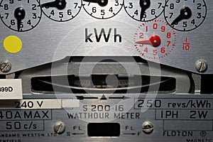 Close-up of a domestic kWh electric meter and slow turning measuring dial.