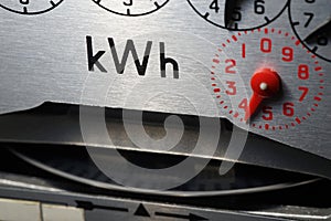 Close-up of a domestic kWh electric meter and slow turning measuring dial.