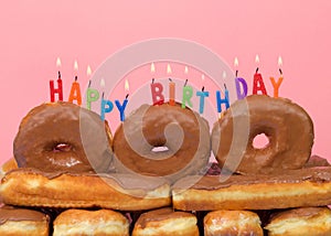 Close up on donut cake with Happy Birthday candles burning