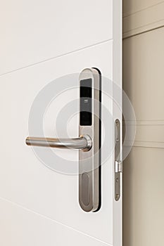 Close-up of doorknob with a digital lock on white door at the entrance to a hotel room. Concept of a modern protective