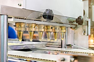 Close up dough or cream and nozzle discharge of automatic biscuit or sweets making machine in production line for high technology