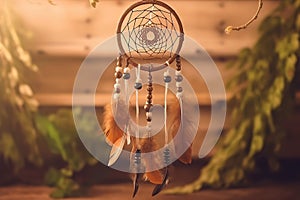 Close up of dream catcher on blurred background in evening sun light in vintage colors.